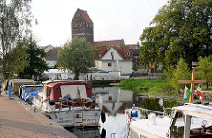 Sportboothafen / Marina in Parchim, Elde-Müritz-Wasserweg; Motorboote an Liegeplätzen mit Stromanschluss - im Hintergrund der Kirchturm der Parchimer Marienkirche.