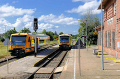 Nahverkehrszüge am Bahnhof Neustadt Glewe; das Bahnhofsgebäude ist stillgelegt.