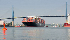Der Containerfrachter APL MERLION auf der Süderelbe in Fahrt zum Hamburger Container Terminal Altenwerder - der 368m lange Megaboxer kann 14 000 TEU Container an Bord nehmen. LKW mit Containern fahren auf der Köhlbrandbrücke.