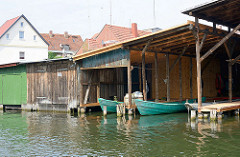 Bootshäuser von Fischerbooten am Ufer der Elde Müritz Wasserstrasse in Plau am See.