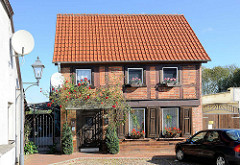 Kleines Fachwerk-Wohnhaus mit Rosenstrauch am Eingang / Blumenkästen; Bilder aus Neustadt-Glewe.