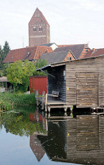 Bootsschuppen / Holzschuppen an der Alten Elde in Parchim - Dächer der Stadt; Kirchturm der Marienkirche.