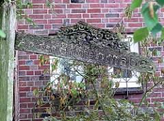 Altes Strassenschild - Holzschild von Hand geschnitzt; An der Blütenmauer in der Gartenstadt von Hamburg Alsterdorf.