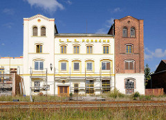 Teilweise renoviertes, gestrichenes Lagergebäude / Fabrikgebäude an den Bahngleisen von Neustadt Glewe - die Ziegelfassade / Backsteinfassade ist teilweise weiss gestrichen.