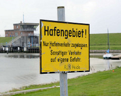 Schild Hafengebiet - im Hintergrund die Schleuse am Friedrichskooger Hafen.