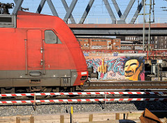 Eisenbahnstrecke an der Versmannstrasse; Graffiti an einer Hauswand - Lokomotive.