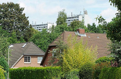 Einzelhäuser mit Satteldach, Seitenstrasse Hamburg Langenbek - Hochhäuser von Hamburg Sinstorf im Hintergrund.