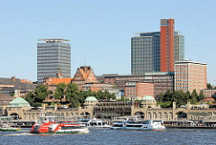 Panoram der St. Pauli Landungsbrücken -  eine Hafenfähre fährt zum Anleger - Fahrgastschiffe am Ponton - Hochhäuser auf Hamburg St. Pauli.