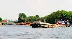 Ein Schubschiff mit Schute fährt in den Reiherstiegkanal ein - dahinter der Klütjenfelder Hafen und die Zufahrt zum Spreehafen in Hamburg Wilhelmsburg.