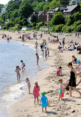 Strandleben an der Elbe in Hamburg Othmarschen - Sandstrand an der Elbe; am Wasser spielende Kinder in der Sonne.