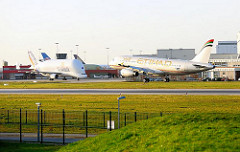Start und Landebahn der Flugzeugwerft EADS / Airbus Hamburg Finkenwerder. Ein Flugzeug der Vereinigten Emirate setzt zur Landung an - im Hintergrund ein Beluga-Transportflugzeug.