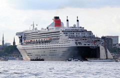 Das Passagierschiff Queen Mary 2 fährt elbabwärts in Höhe Hamburg Altona - kleine Sportboote und Barkassen begleiten das grosse Passagierschiff.