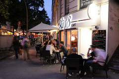 Später Abend in Hamburg Winterhude - die Cafes und Restaurants sind gut besetzt, die Winterhude schlendern durch das Viertel.