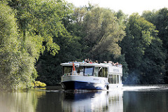 Ausflugsschiff der Bergedorfer Schifffahrtslinie auf der Doveelbe vor Hamburg Neuengamme - Bäume stehen bis dicht an das Ufer des Flusse..