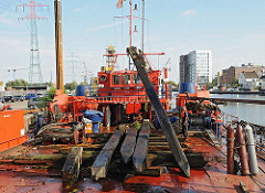 Harburger Binnenhafen - entfernen von Holzdalben, Holzpfählen aus dem Hafenbecken - Arbeitsboot.