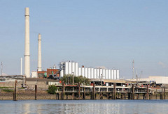 Bilder Wilhelmsburger Industriearchitektur - Silos und Schornsteine; am Ufer des Reiherstieg ein Anlegeplatz für Tankschiffe und die dazugehörigen Verladevorrichtungen.