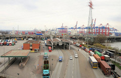 Zollanlage des Hauptzollamts Waltershof - beladene LKW stehen in der Warteschlange um ihre Ladung zu den Containerterminals bringen zu können - im Hintergrund Containerkräne / Hafenanlagen des Waltershofer Hafens.
