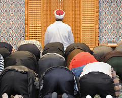 Gebetsraum Eyüp Sultan Moschee - Hamburg Harburg, Imam Ibrahim Sökmen vor der Qibla-Wand.