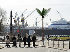 Parc Fiction, Antonipark an der Elbe - Fussgängerinnen mit Kinderkarre - Kreuzfahrtschiff eingedockt.