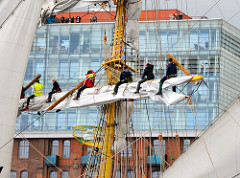 Segelschiff im Hamburger Hafen zum Hafengeburtstag - Menschen auf einer Rahe vor Hamburg Altona.