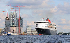 Die Queen Mary 2 hat ihren Liegeplatz am Cruisecenter in der Hamburger Hafencity verlassen und befindet sich in Höhe der Baustelle der Elbphilharmonie.