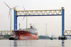 Kattwyckbrücke an der Süderelbe - das Mittelteil der Hubbrücke ist hochgefahren, ein Frachtschiff fährt mit Schlepperunterstützung auf der Süderelbe.