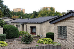 Wohnhäuser mit Flachdach und gelber Klinkerfassade beim Falkenberg - im Hintergrund Hochhäuser von Neuwiedenthal. Hamburgs Architekturbilder.