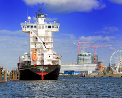 Frachtschiff auf Reede an den Dalben in der Norderelbe - im Hintergrund Gebäude der Hafencity Hamburgs.