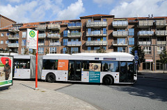 Bushaltestelle in Schnelsen Nord - Roman Zeller Platz. Ein HVV Gelenkbus fährt in die Kurve.