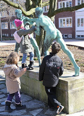 Schulkinder turnen auf der Bronzeskulptur "Faustkämpfer" voM Bildhauer Eberhard Encke, geschaffen 1913.