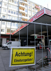 Bauzaun mit dem Schild Achtung Einsturzgefahr vor der Essotankstelle Reeperbahn - mehrstöckiges Wohnhaus, die Balkons sind mit Balken abgestützt.