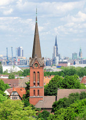Kirchturm der ev. luth. Emmauskirche in Hamburg Wilhelmsburg - erbaut 1895, Architekt Hugo Louis. Im Hintergrund die St. Nikolaikirche und der Rathausturm.