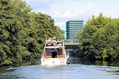 Fahrt im Schleusengraben - ein Motorboot fährt Richtung Hamburg Bergedorf - im Hintergrund das Hochhaus am Bergedorfer Hafen.