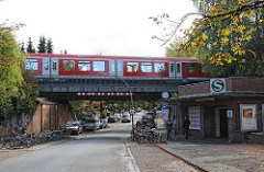 S-Bahnstation Kornweg - Bahnbrücke über die Strasse - roter S-Bahnzug.