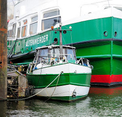 Eine alte HADAG - Fähre Altenwerder und ein Motorboot im Hafen von Hamburg Finkenwerder.