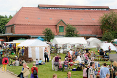 Bauernmarkt auf dem Biogut Wulksfelde - Zelte und Gebäude mit Ziegeldach.