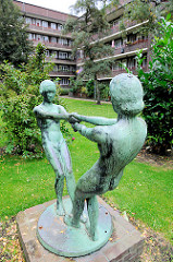 Bronzeskulptur Tanzende Mädchen - Innenhof mit Sträucher im Hamburger Stadtteil Dulsberg.