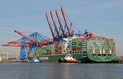 Ein Containerschiff legt mit Hilfe von Schleppern unter der Containerbrücke des HHLA Terminals Burchardkai an.