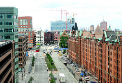 Moderne Architektur und historische Lagergebäude in der Hamburger Hafencity - Blick in die Strasse Am Sandtorkai - im Hintergrund die Baustelle der Elbphilharmonie.
