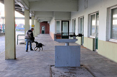 Rampe der stillgelegten Zollstation Reiherstieg Hauptdeich - Fussgängerin mit Hund in Hamburg Wilhelmsburg.