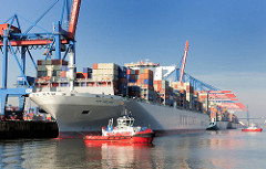 Der Containerfrachter NYK HELIOS am Containerterminal Hamburg Altenwerder; Schlepper unterstützen das Schiff beim Ablegen und Auslaufen aus dem Hamburger Hafen. Das 2013 gebaute Containerschiff hat eine Länge von 365,50m und eine Breite von 48,40m; d