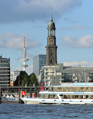Wahrzeichen von Hamburg - Blick über die Elbe zum Michel und Telemichel. Schiffsbug mit Hamburgflagge.