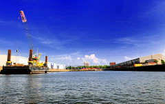 Blick in den Baakenhafen der Hamburger Hafencity - am Versmannkai liegt ein grosser Arbeitsponotn - rechts Lagerhallen am Petersenkai; im Hintergrund  ein Hochhaus in Hamburg Rothenburgsort.