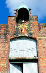 Winde auf dem Dach des Speicher G mit Kupferdach. Fassadenschmuck mit farbigen Ziegeln gemauer.