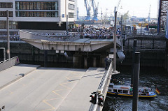 Klappbrücke über die Einfahrt vom Sandtorhafen in der Hafencity - die Brücke schliesst sich - eine Barkasse fährt in das Hafenbecken ein.