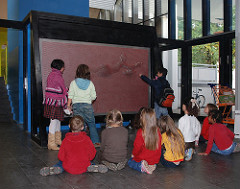 Kindermuseum Hamburg - Osdorf - eine Klasse sitzt vor einem Objekt im Museum.