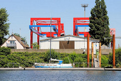Sportboot am Schlengel im Dradenauhafen - im Hintergrund Containeranlagen des Waltershofer Hafens.