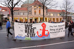 Demonstration Januar 2014 in Solidarität mit der Gruppe Lampedusa in Hamburg, der Essohäuser Initiative und den Betroffenen des Gefahrengebietes in der Edmund Siemers Allee, Universität Hamburg - Transparent - We are here to stay, Lampedusa in Hambur