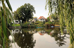 Einzelhäuser / Alstergrundstücke am Ufer vom Alsterkanal; Weidenzweige - Kanu auf dem Fluss.