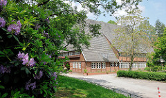Bauernhaus mit Biergarten im Altonaer Volkspark / Stadtteil Hamburg Bahrenfeld; blühende Rhododendron.